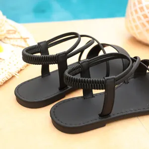 Close-up of black Roman flat sandals featuring comfortable elastic heel straps for beach wear