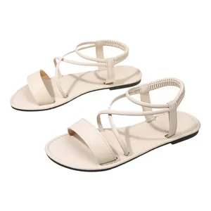 Close-up detail of cream-colored women's flat Roman sandals with soft elastic straps