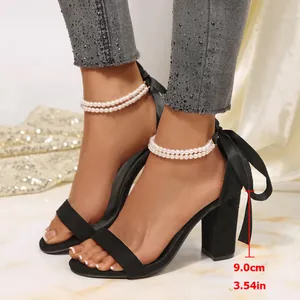 Detail view of black satin block heel sandals with pearl straps and 9cm heel height