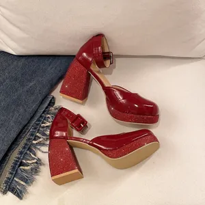 Detail of red patent leather Mary Jane shoes with rhinestone-encrusted chunky heels and platforms.