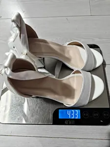 Weight measurement of white satin chunky heel sandals on a digital scale showing 433g.