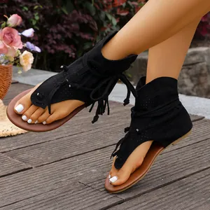 Elegantes sandalias negras de caña alta con flecos y diseño romano calado.