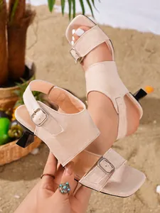 Close-up view of beige suede square-toe sandals featuring a unique sculptural heel