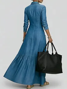 Back view of a vintage blue denim maxi dress with a tiered skirt and cinched waist.