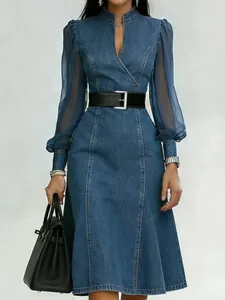 Close-up detail of a blue denim midi dress featuring elegant sheer mesh puff sleeves