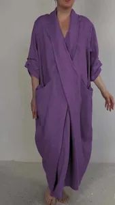 Full-length front view of a purple linen maxi dress featuring a V-neck and large side pockets.