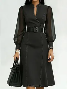 Detailed view of black denim dress featuring sheer lantern sleeves and a belted waist.