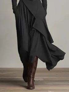 Detailansicht eines eleganten schwarzen langärmeligen Wickelkleides mit Lagenrock-Design