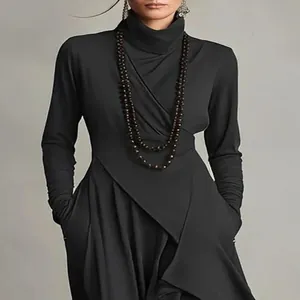 Detailansicht eines eleganten schwarzen Wickelkleides mit hohem Kragen, Ärmeln und Taschen