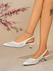 Gros plan de talons slingback blancs à bout pointu avec motifs ajourés sophistiqués