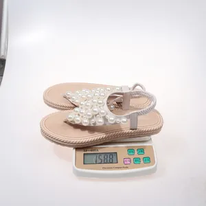 Dettaglio dei sandali beige leggeri da donna con decorazioni in perle sintetiche