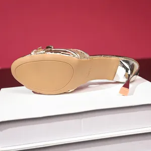 Close-up detail of the anti-slip sole and elegant stiletto heel of gold glitter sandals