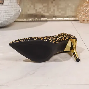 Detailed view of black and gold leopard print stiletto heels with elegant pointed toe.