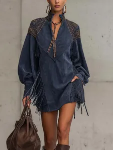 Détail d'une robe de style bohème montrant des franges complexes et des broderies