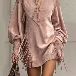Détail d'une robe en daim rose à col en V avec des franges et des broderies