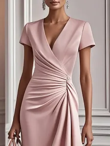 Elegant dusty pink satin dress detail featuring a deep V-neck and ruched waistline