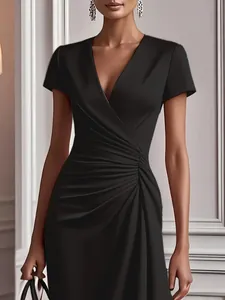 Detail view of an elegant black short sleeve dress with cross V-neck and ruched waist.