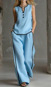 Dettaglio del top smanicato celeste e dei pantaloni a gamba larga con profili neri.