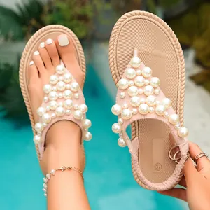 Eleganti sandali infradito rosa decorati con perle per le vacanze al mare.