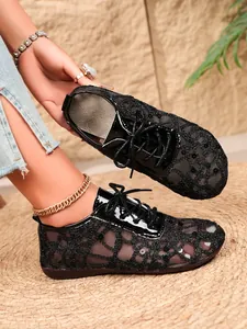 Detailed view of black lace mesh flats with sequins and lace-up design for women.