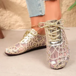 Detail of women's gold mesh lace-up flats with sparkly sequin hollow-out pattern.