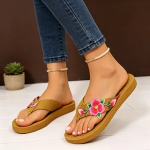 Dettaglio di infradito con zeppa e ricamo floreale rosa per abbigliamento estivo