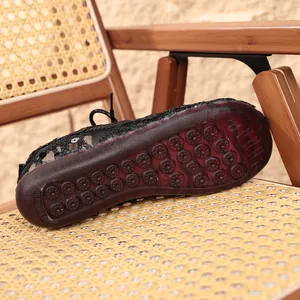 Detail view of the durable non-slip rubber sole on black lace mesh flats.