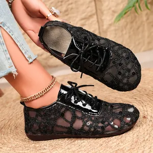 Detailed view of black lace mesh flats featuring sequin embellishments and lace-up design