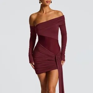 Dettaglio mini abito bordeaux con spalle scoperte, tessuto plissettato e vita in mesh