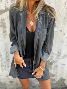 Detalle de una chaqueta vaquera gris lavada casual con un elegante colgante de corazón