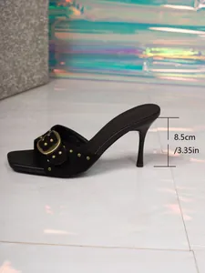 Λεπτομερής όψη μαύρου mule με τακούνι στιλέτο 8,5 cm και χρυσή αγκράφα.