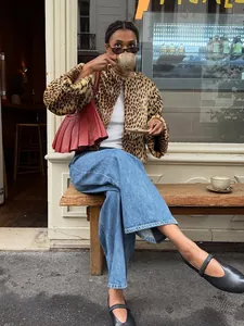 Stilvolle Kurzjacke mit Leopardenmuster kombiniert mit Jeans in einer trendigen Stadtumgebung.
