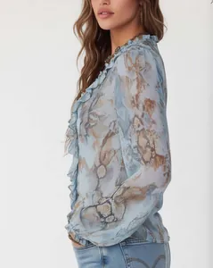 Detailed view of ruffled cuffs and snake print pattern on semi-sheer blue blouse