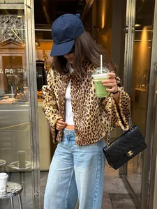 Streetstyle-Detail einer trendigen Frau in einer kurzen Kunstpelzjacke mit Leopardenmuster im Café.