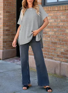 Detailed view of women's loose grey knitted short sleeve top with casual wide-leg jeans