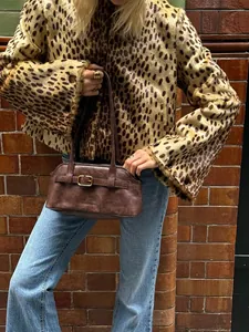 Detailansicht einer modischen kurzen Jacke mit Leopardenmuster und Kunstpelz zu blauen Jeans.