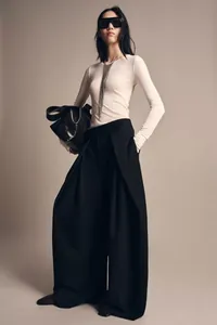 Close-up of black wide-leg trousers with elegant drape and relaxed fit for women.