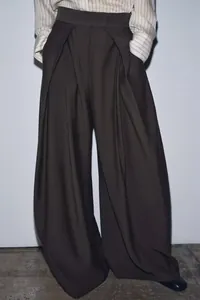 Detail view of high-waist loose wide-leg trousers with elegant pleats and drape texture