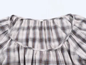 Primer plano detallado del cuello redondo y los pliegues de una camisa a cuadros