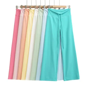 Hoge taille yoga broeken met wijde pijpen in diverse pastelkleuren aan een houten hanger