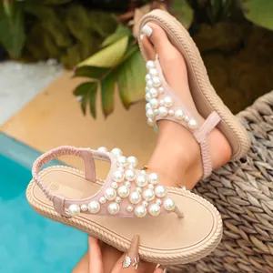 Dettaglio di sandali rosa con decorazioni in perle di lusso e un elegante design di infradito.
