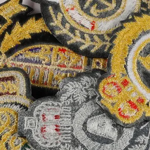 Vista dettagliata di vari stemmi ricamati in stile collegiale in oro e argento