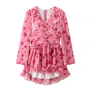 Détail d'une robe fleurie rose à manches longues avec ourlet volanté et boutons bijoux