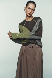 Detail eines übergroßen Retro-Strickpullovers mit Rautenmuster in Erdtönen für Damen