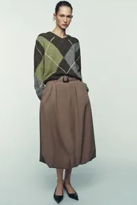 Vintage-Strickpullover mit Rautenmuster, kombiniert mit einem stilvollen Midirock für Herbst.