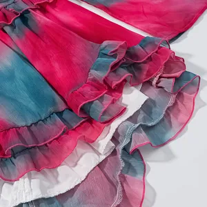 Gros plan détaillé sur l'ourlet à volants tie-dye rose et bleu d'une robe d'été légère