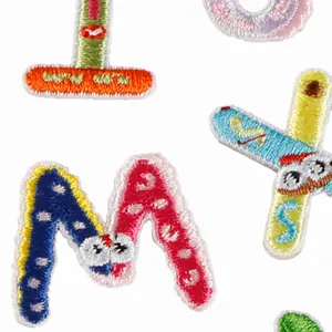 Colorful embroidered cartoon monster alphabet patches for iron-on clothing decoration.