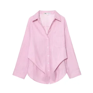 Dettaglio di una camicia a righe rosa con maniche a pipistrello e tasca sul petto