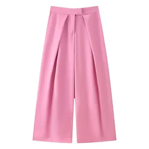 Detail view of stylish pink wide-leg trousers showing elegant drape and waist pleats.