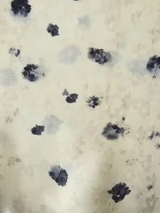 Dettaglio ravvicinato della stampa floreale su tessuto di raso color crema lucido